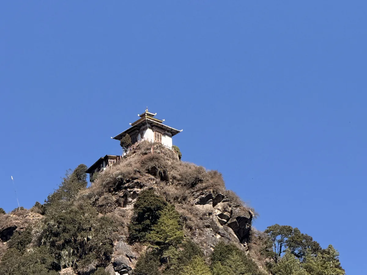 A small lhakhang on its rock outcrop above the path