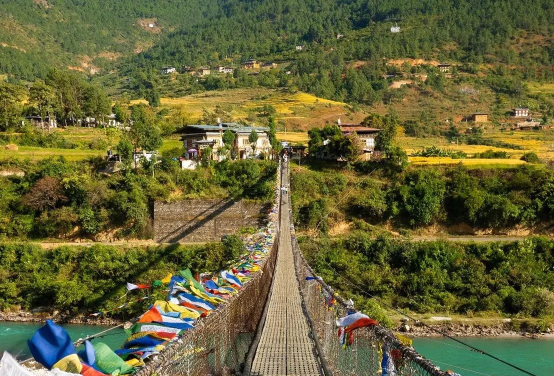 Prayer-flag suspension bridge over the river below the valley